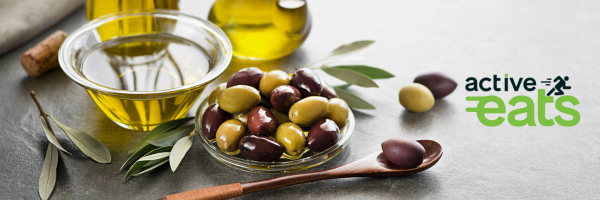 Image showing green and maroon olives and olive oil next to it in a glass bowl