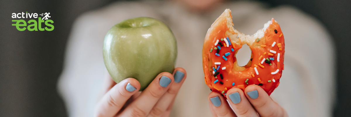 Picture shows that hands of a lady holding apple which is a source of natural sugar in one hand and donut on other hand which represents artificial sugar. IT indicates how difficulty it is to control sugar cravings.