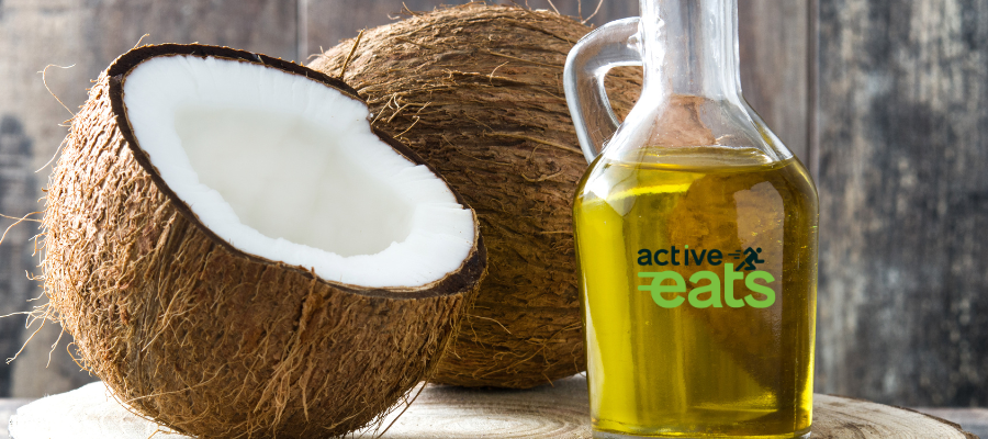 Image shows half coconut and coconut oil in a glass bottle next to it.